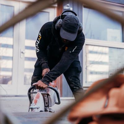 Medewerker van Dorrestijn zaagt een betonband