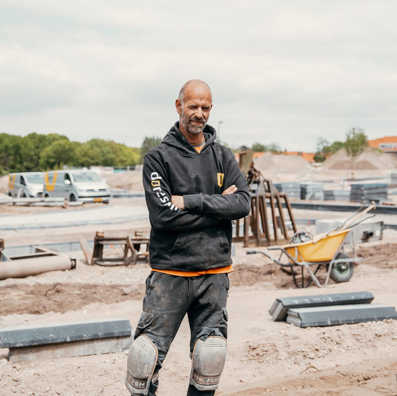 Medewerker van Dorrestijn met gekruiste armen op een bouwterrein