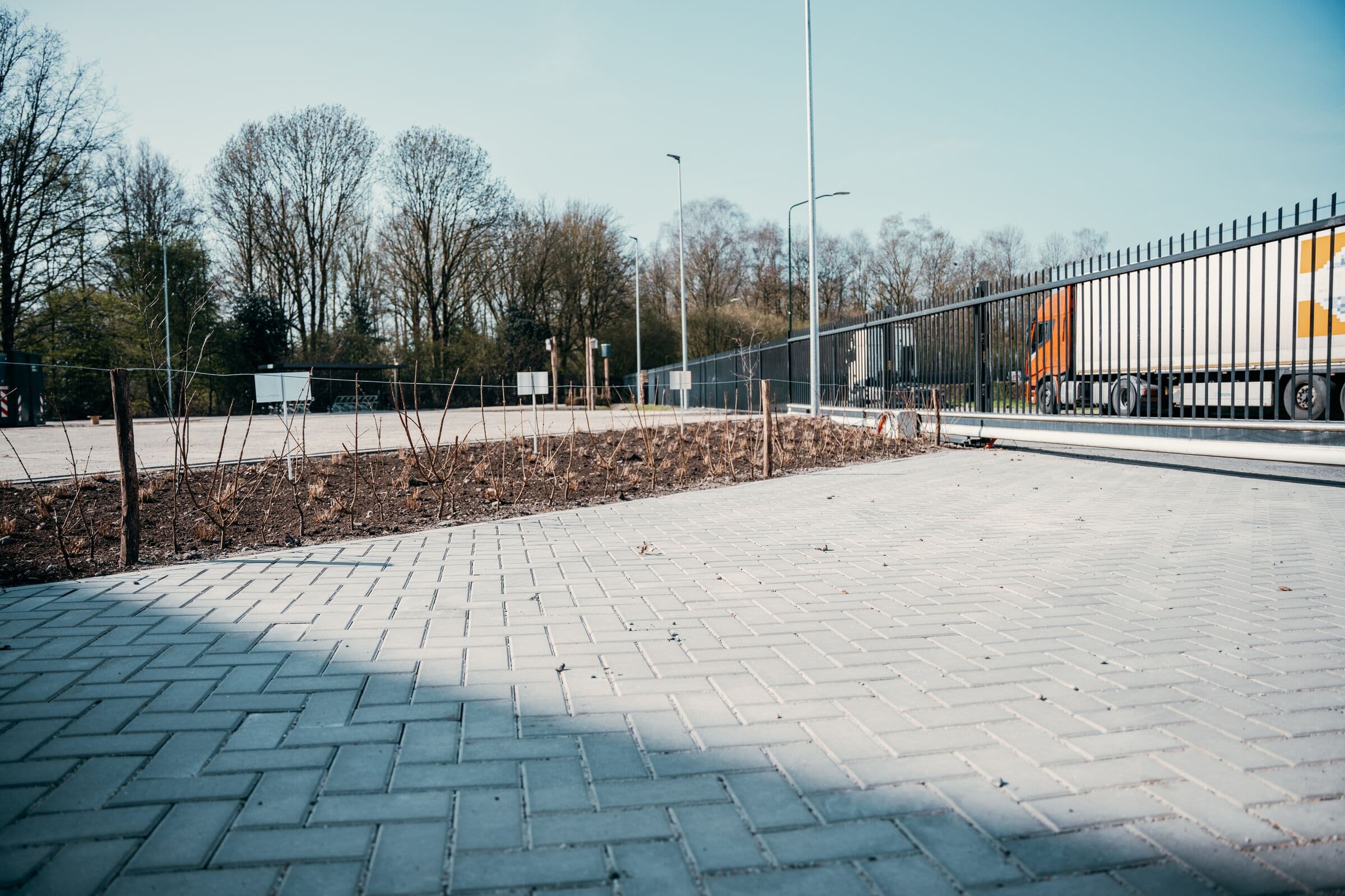 Nieuw straatwerk en plantvakken langs een bedrijfsterrein